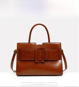 Detailed view of dark brown retro tote bag featuring a large square buckle and silver hardware