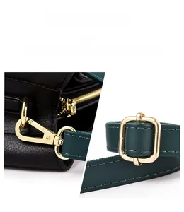 Close-up of golden hardware latch and zip on black lychee grain leather tote bag
