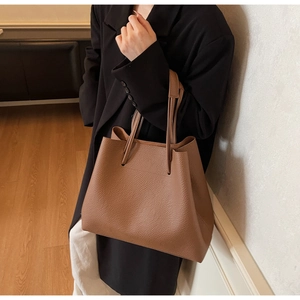 Detailed close-up of brown lychee grain leather tote bag with unique multi-cord handle