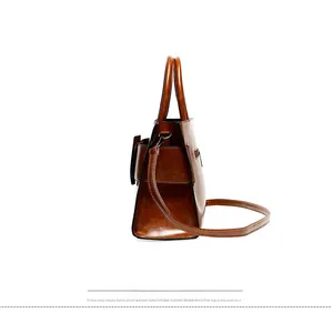 Detailed side profile of retro brown leather handbag with reinforced stitching and dual handles