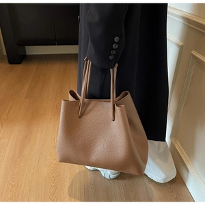 Detail of deep brown lychee grain leather tote bag with fine stitching and texture