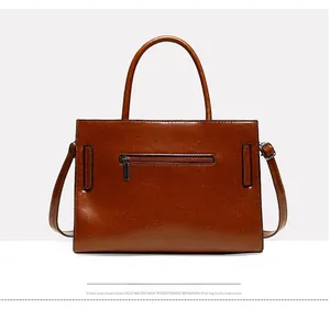 Macro detail of dark brown oil wax leather tote bag featuring a rear zipper pocket