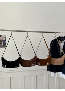 Detail view of four suede crescent bags in black, coffee, caramel and beige colors