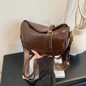 Brown faux leather crossbody bag with geometric wide strap and polished finish