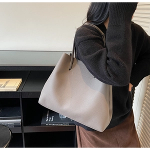 Detail view of elephant gray tote bag with litchi grain leather and slim shoulder strap