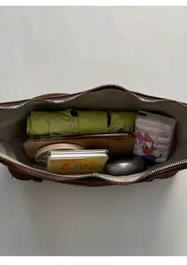 Top view showing internal storage of the brown crossbody bag with umbrella and phone