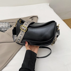 Chic black crescent shoulder bag with a patterned wide strap and smooth leather finish