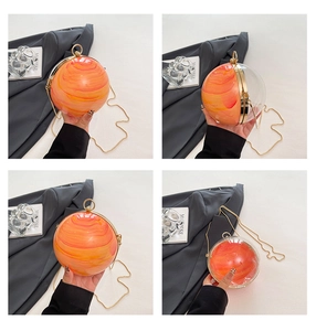 Vue détaillée du sac de soirée rond en acrylique avec texture marbre orange et anse dorée