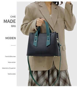Detail of lychee pattern leather tote with green handle and gold metal hardware accents