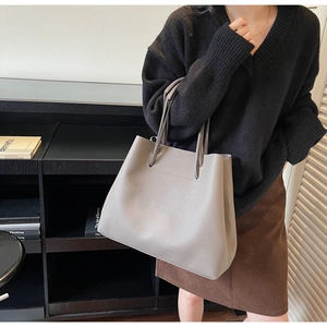 Close-up of grey litchi texture leather tote bag with elegant matte finish details