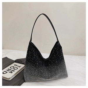 Detailed macro view of gradient silver rhinestones on a stylish black hobo bag