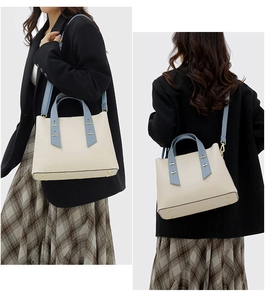 Detail of minimalist tote bag with blue trim and gold hardware in urban style