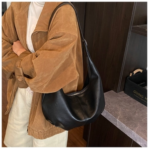 Détail d'un grand sac bandoulière noir en similicuir avec fermeture éclair en métal