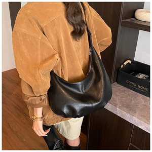 Gros plan d'un sac demi-lune en cuir noir mat avec fermeture éclair pour usage quotidien