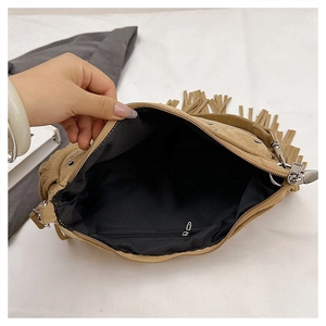 Interior detail of tan faux suede tassel bag with black lining and internal zipper pocket