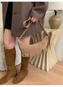 Detail showing khaki suede dumpling bag with elegant silver buckles and retro aesthetic
