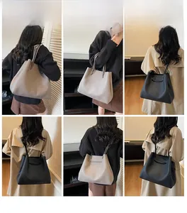 Detail view of large leather tote bags in black and dark grey with pebbled texture