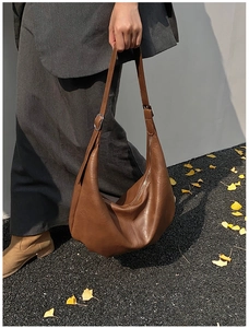Détail de la texture en cuir PU marron et boucle argentée sur grand sac hobo souple
