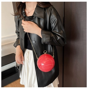 Détail du sac de soirée sphérique en acrylique marbré rouge avec cadre doré
