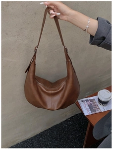 Gros plan détaillé d'un sac bandoulière marron en simili cuir avec coutures et fermeture éclair