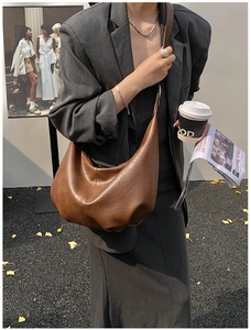 Détail de la texture en cuir marron plissé sur un grand sac hobo pour le bureau