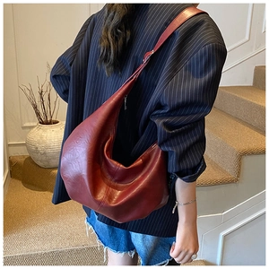 Grand sac hobo en cuir bordeaux porté à l'épaule pour un style décontracté moderne