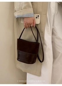 Détail du sac seau marron foncé mêlant suède et cuir lisse avec fines anses