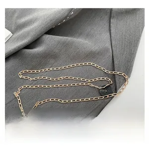 Close-up of gold chain strap and metal clasp on sequin leopard evening bag