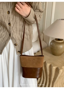 Detail of vintage brown bucket bag with mixed matte suede and smooth leather textures