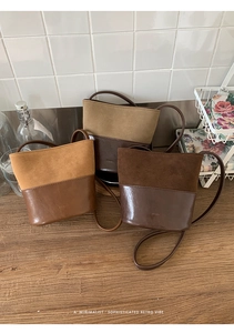 Détail de trois sacs seaux rétro en tons marron sur une table en bois de style rustique