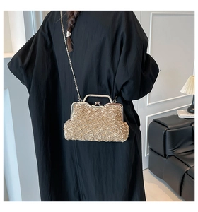 Detail of golden sequined evening bag featuring a vintage clasp and elegant metal chain strap