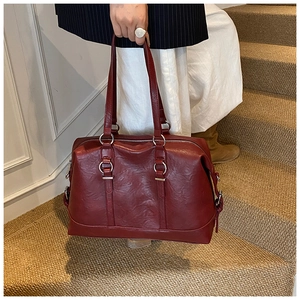 Detail of burgundy vintage doctor bag with silver hardware on carpet stairs