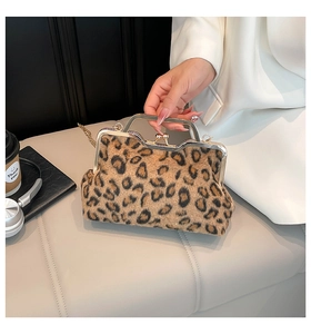 Detail shot of leopard print faux fur clutch bag with gold chain in a lifestyle setting
