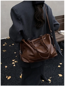 Outdoor shot of a vintage dark brown leather travel tote showing its large capacity size
