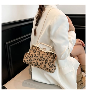 Detail of leopard print crossbody bag with vintage gold kiss-lock closure and metal chain