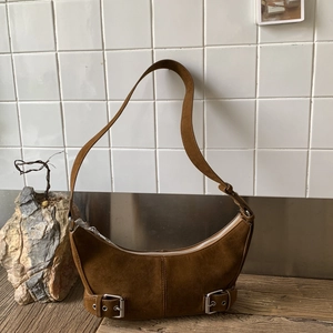 Minimalist caramel suede hobo bag with crescent shape and stylish silver buckle details