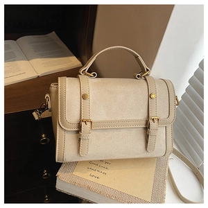Détail du sac messager rétro en matière mate avec boucles dorées et bandoulière
