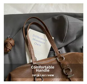 Detail of comfortable brown leather handles and smooth silver zipper on a vintage tote bag