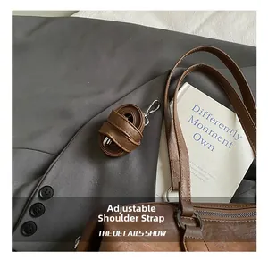 Close-up of adjustable brown leather shoulder strap with silver buckle and pebbled texture