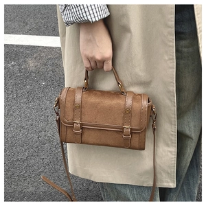 Détail du sac messager marron vintage avec double boucle et quincaillerie en bronze