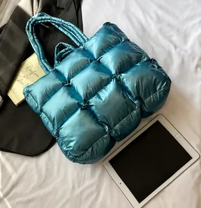 Primer plano del bolso tote acolchado azul metálico con textura suave y costuras