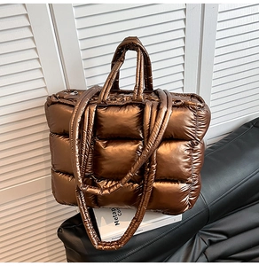 Detailansicht der gesteppten Puffertasche in Metallic-Bronze mit Schultergurt