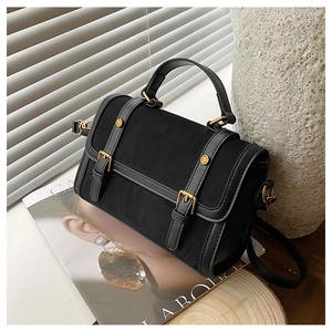 Détails du sac bandoulière noir avec textures en daim et boucles métalliques dorées