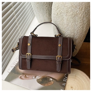 Détail macro d'un sac messager marron foncé mat avec boucle métallique rétro et garniture en cuir