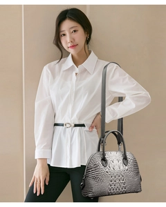 Détails de la texture crocodile gris dégradé sur un sac à main chic en forme de coquille