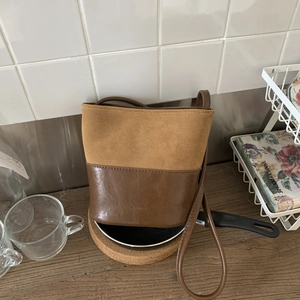 Vintage bucket bag with brown faux leather and suede patchwork and a long shoulder strap