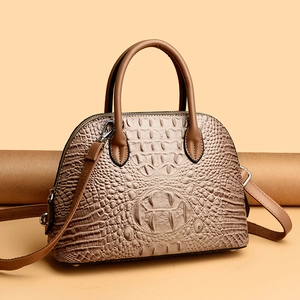 Gros plan sur la texture crocodile marron clair d'un sac à main en forme de coquille