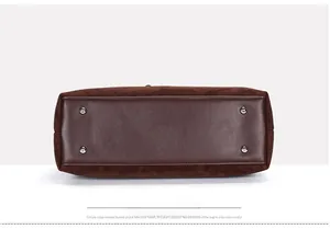 Detail of brown tote bag bottom with silver studs and premium suede leather splicing