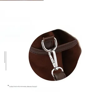 Detail of silver metal spring clasp and matte brown leather strap on tote bag