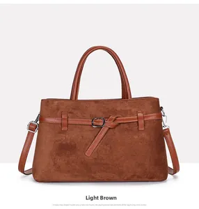 Detail of light brown matte tote bag showing suede texture, buckle design, and silver hardware